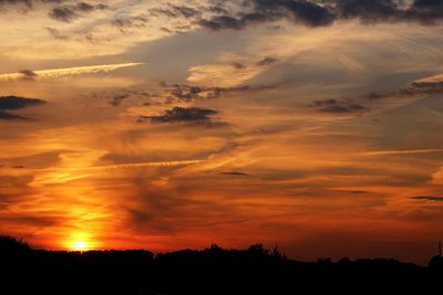 Scenic view of dramatic sky over silhouette landscape