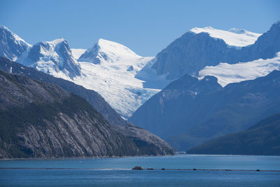 Scenic view of sea and snowcapped mountains against sky