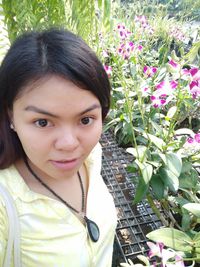 Portrait of smiling woman with flowering plants