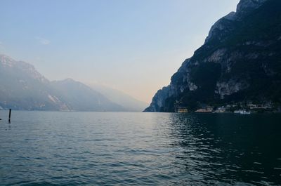 Scenic view of sea by mountains against sky