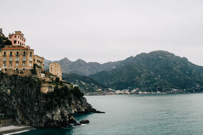 Scenic view of residential building on rocky coastline