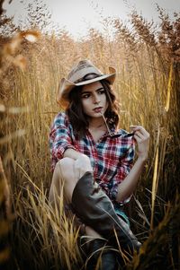 Portrait of young woman sitting on field