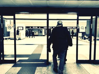 Rear view of man walking at railroad station