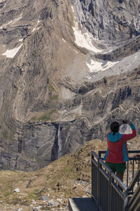 Young traveler taking photo with a phone over the mountain