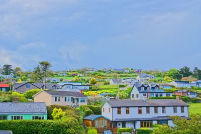 Houses and buildings in town against sky