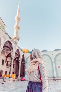 Midsection of woman standing outside building against sky