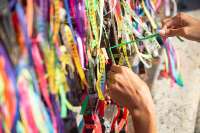 People are seen paying homage to senhor do bonfim by tying a souvenir ribbon 