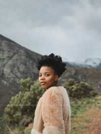 Side view of young woman looking away against sky