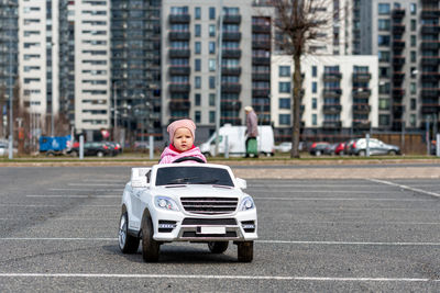 Little girldriving a toy car. little driver, childrens car, concept of road safety, children in car