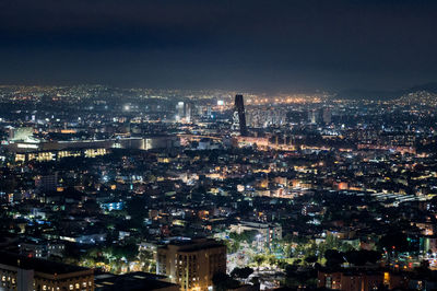 High angle view of illuminated buildings against sky at night