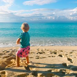 Full length of boy standing on beach against sky