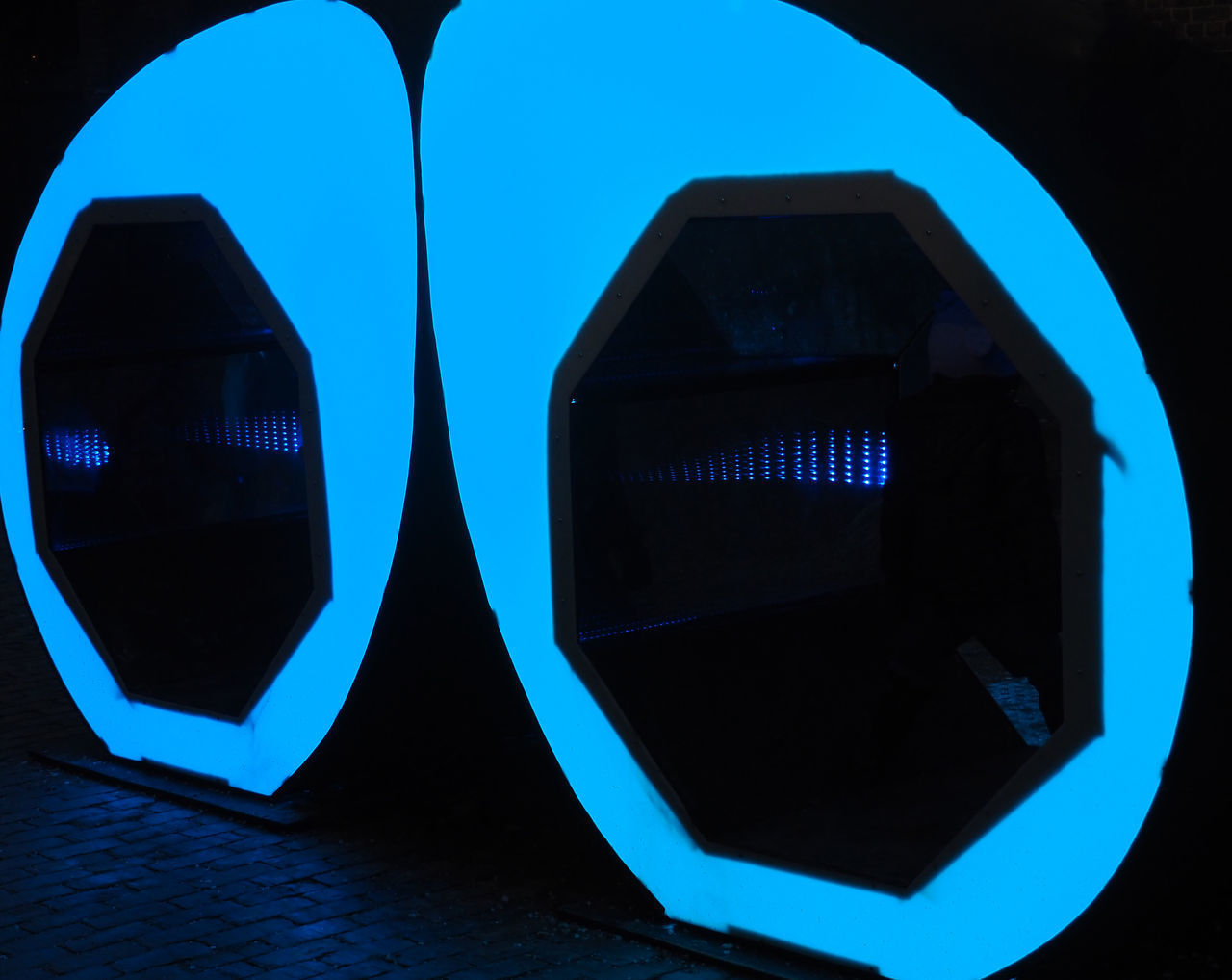 CLOSE-UP OF ILLUMINATED CAR ON STREET AGAINST BLUE SKY