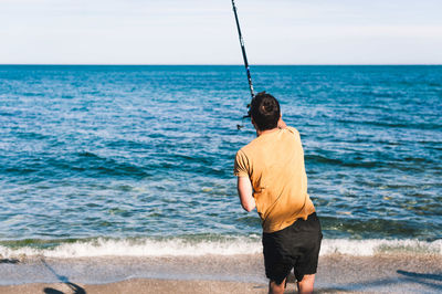 Rear view of man standing on beach