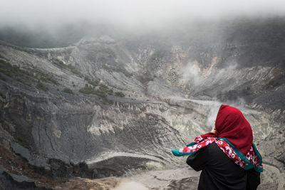 Rear view of woman standing on mountain