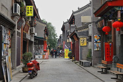 People on street amidst buildings in city