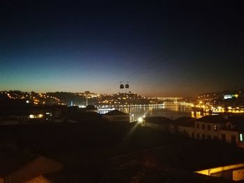 Illuminated cityscape against clear sky at night