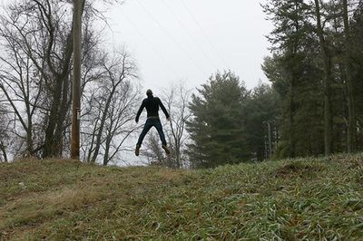 Full length of woman standing on tree trunk