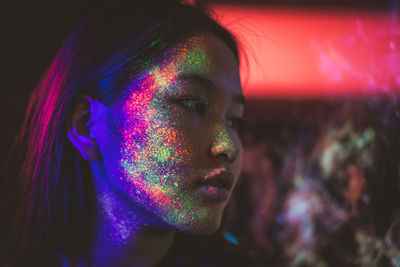 Beautiful young woman with face paint looking away