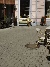 Empty chairs and tables on street in city