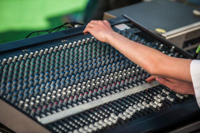 Cropped hands of woman playing sound mixer in recording studio