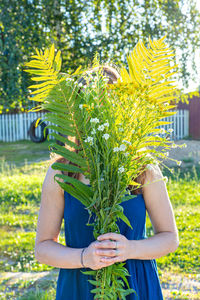 Midsection of man holding flowering plant