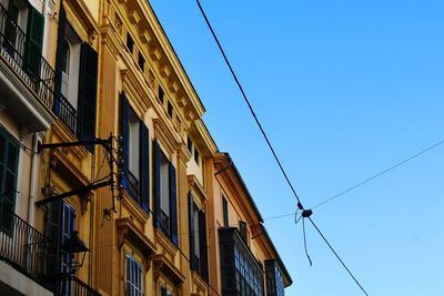 Low angle view of buildings against clear blue sky