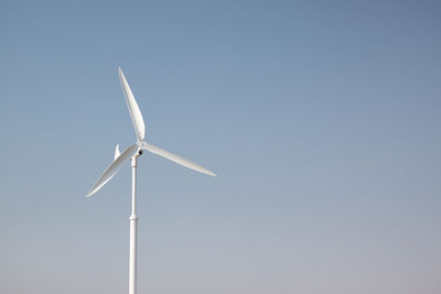 Low angle view of wind turbine against clear sky