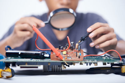 Young schoolboy learning electronic circuit board. detail focus on board component