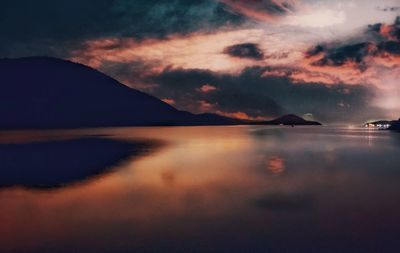 Scenic view of sea against dramatic sky during sunset