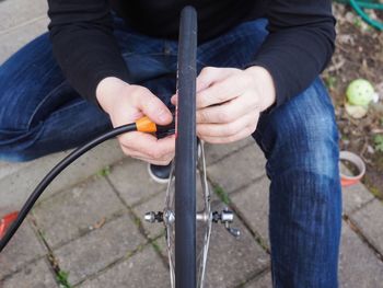 High angle view of man repairing bicycle wheel