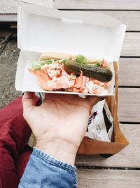 Cropped image of person holding food in box