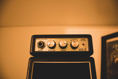 Close-up of telephone booth on table against wall at home