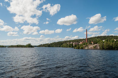 Scenic view of lake by buildings against sky