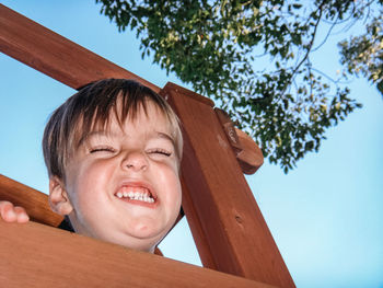 Low angle view of young woman against trees