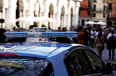 Police car with blue sirens in the main square of the european city with high contrast effect