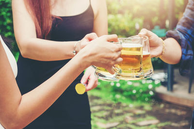 Midsection of woman holding drink in jar