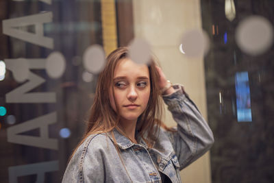 Young woman looking away seen through glass window