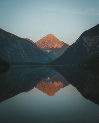 Scenic view of lake by mountains against sky