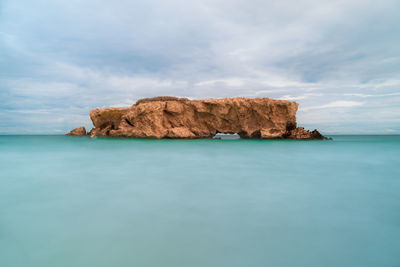 Rock formations in sea against sky