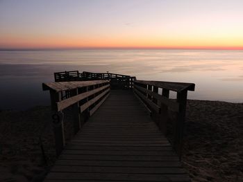 Pier on sea at sunset