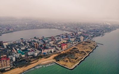 High angle view of city by river against sky