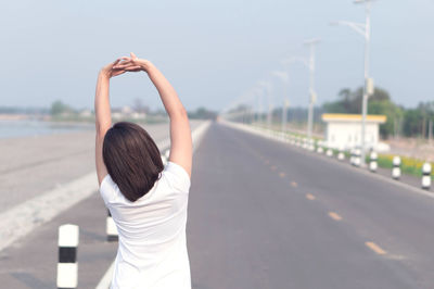 Rear view of woman standing on road