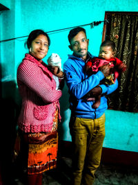Portrait of happy friends standing against wall