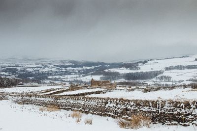 Scenic view of snow covered field against sky