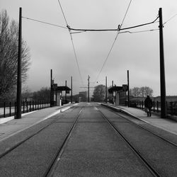 Railroad tracks in city against sky