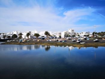 Reflection of houses in town against sky