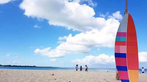 People standing on beach against sky