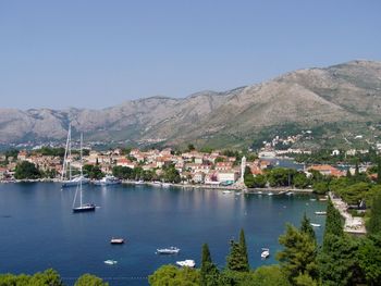 Scenic view of river and mountains against clear blue sky