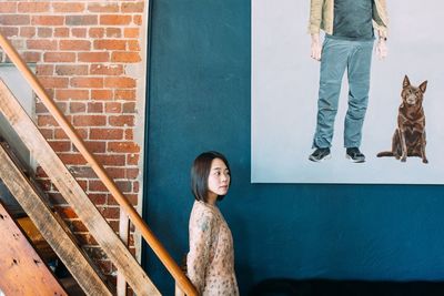 Portrait of woman standing against wall