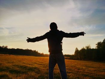 Silhouette of person standing on grassy field